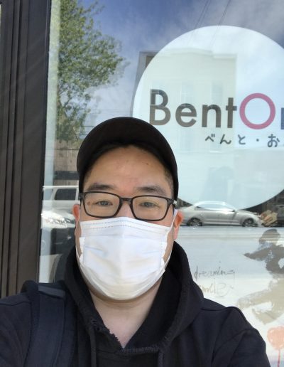 A man wearing a mask standing outside of BentOn