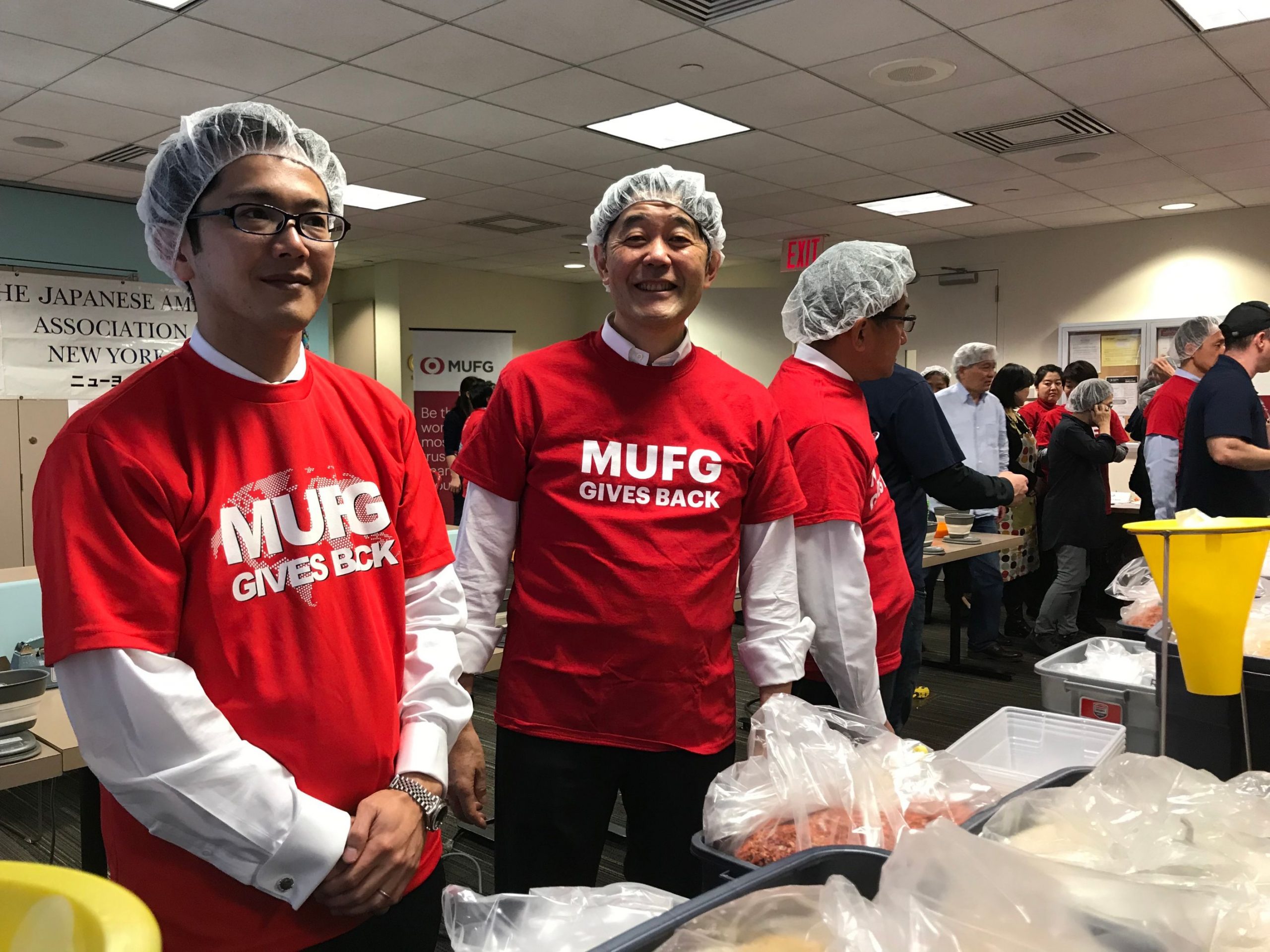 Volunteers wearing red MUFG t-shirts and hairnets